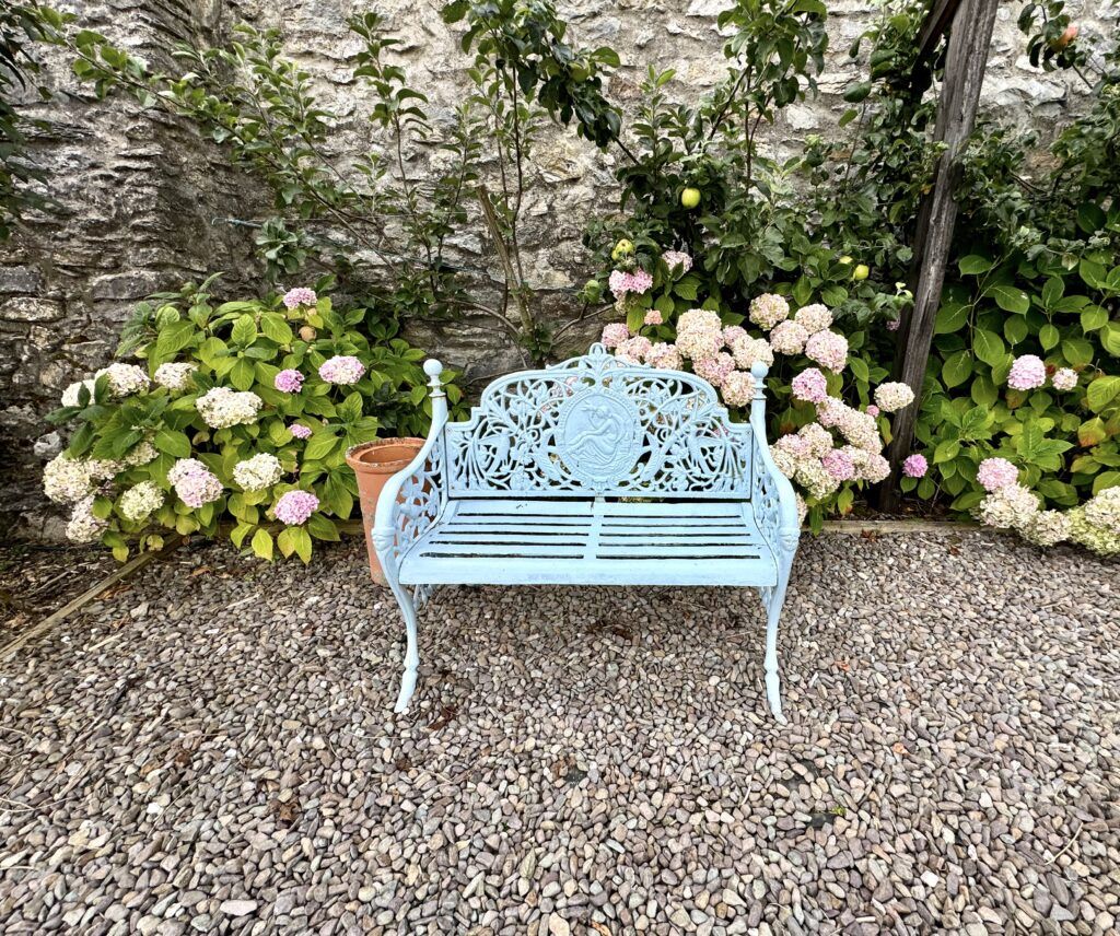 wrought iron bench and rhododendruns