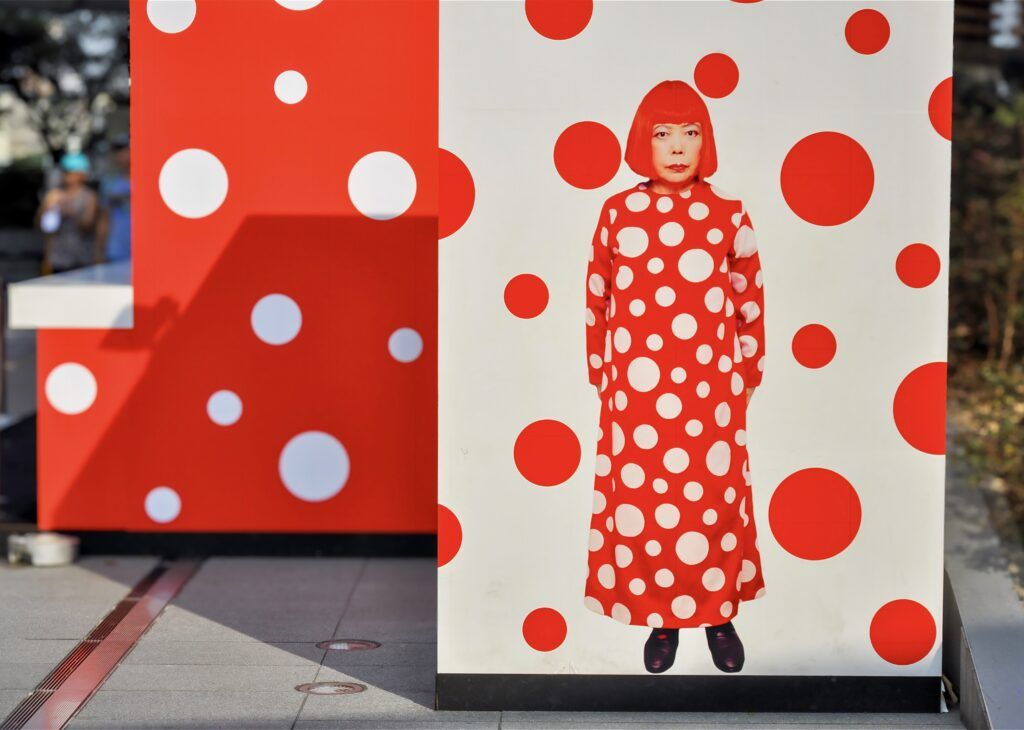 Kusama wearing her iconic red and white polka dot dress, 2013