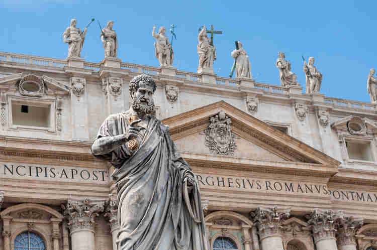 the statue of St. Peter in front of the facade of the basilica