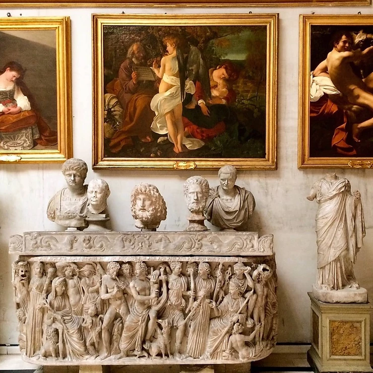 sculptures in the Aldobrandini Room of the Doria Pamphilj, with threeCaravaggio paintings above