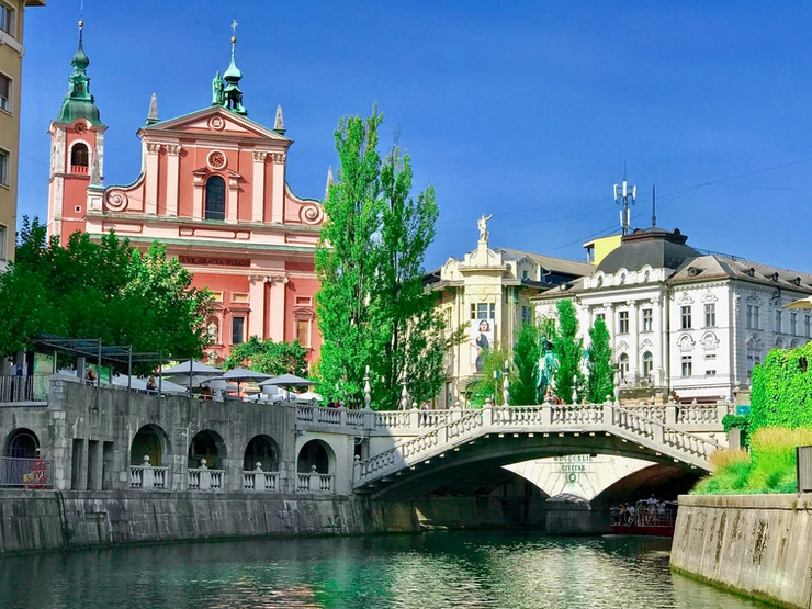 cafes line the leafy banks of the emerald green Ljubljanica River