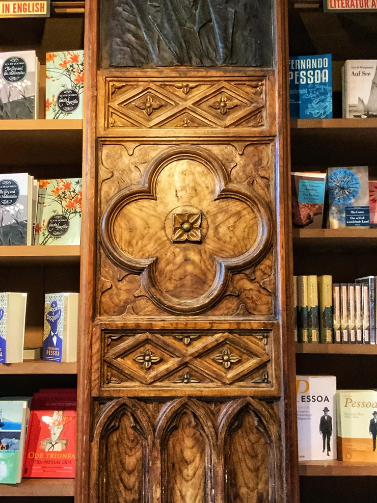a nice little wooden carving against the stacks of books
