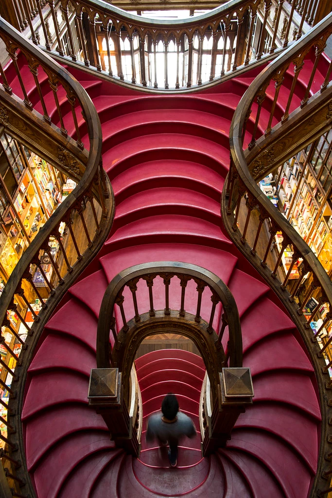 the iconic red staircase of Livraria Lello