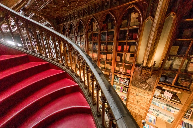 a swirl of staircase and carved wood bookcases