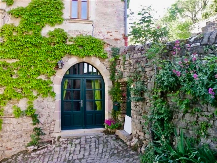 a beautiful stone wall and arched door in Cordes sur Ceil