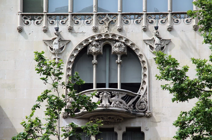 a lovely rounded balcony on the third floor, flanked by winged griffins