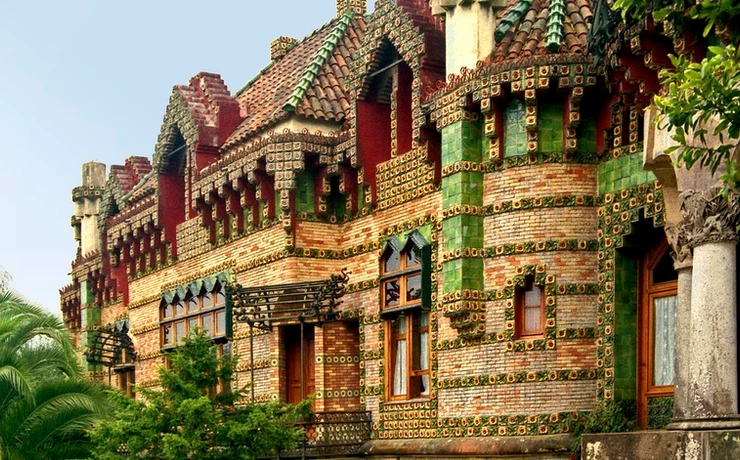 the colorful facade of Gaudi's El Capricho in Comillas, encrusted with sunflowers