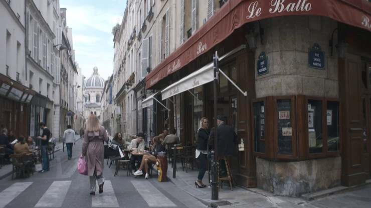 Villanelle walking down Rue Mazarine in Paris -- a street filled with shops, art galleries, and tony restaurants