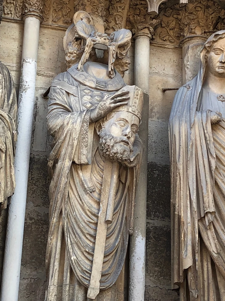 St. Denis holding his head on the facade of Reims Cathedral