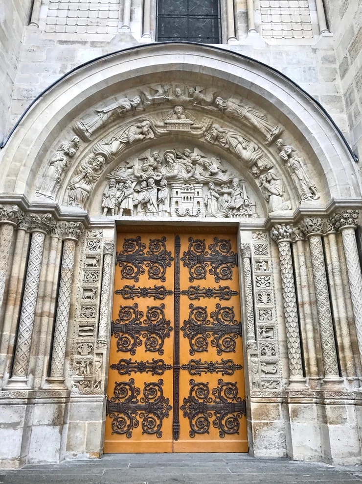 the central entry door to the Basilica de Saint-Denis with ornate wrought iron strap hinges