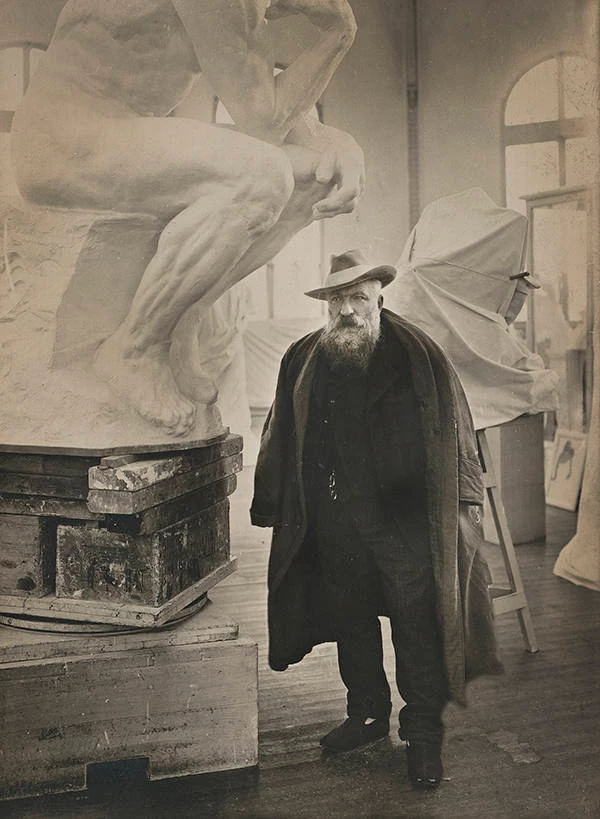 Rodin in his studio next to a plaster model of The Thinker
