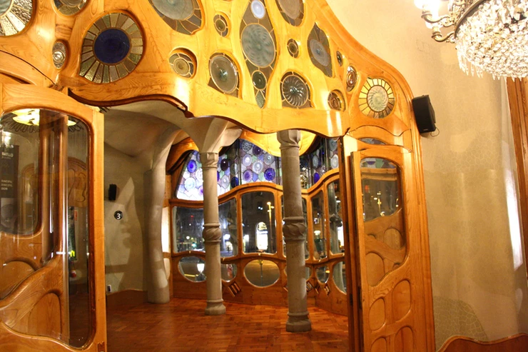 the entrance hall of the Casa Battlo with curving doors and windows and a massive crystal chandelier