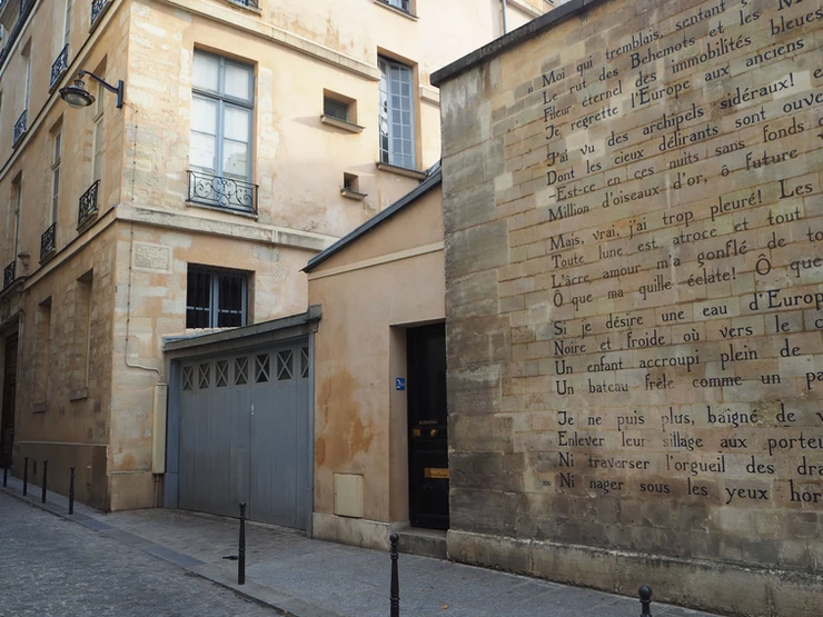 Le Bateau Ivre poem inscribed on a stone street wall on rue Ferou