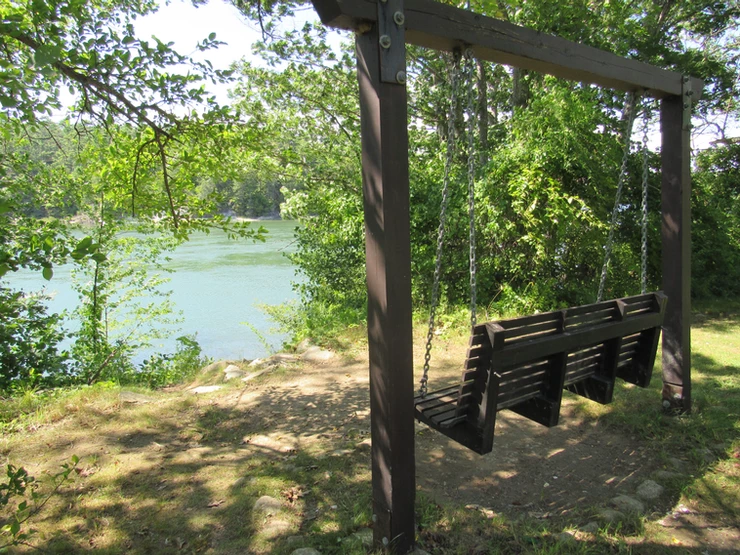 A wooden swing bench facing the Damariscotta River in Maine