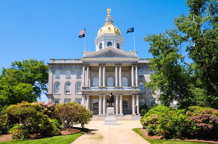the gold domed State House in Concord New Hampshire with a statue of Daniel Webster
