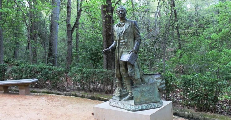 a statue of Washington Irving in a park outside the Alhambra with the inscription "Son of the Alhambra"