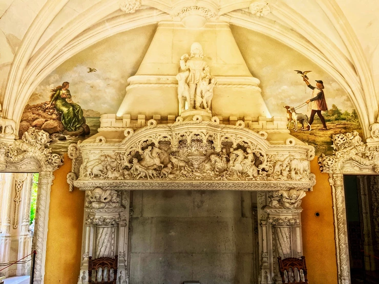 an ornately carved fireplace in the palace of Quinta da Regaleira