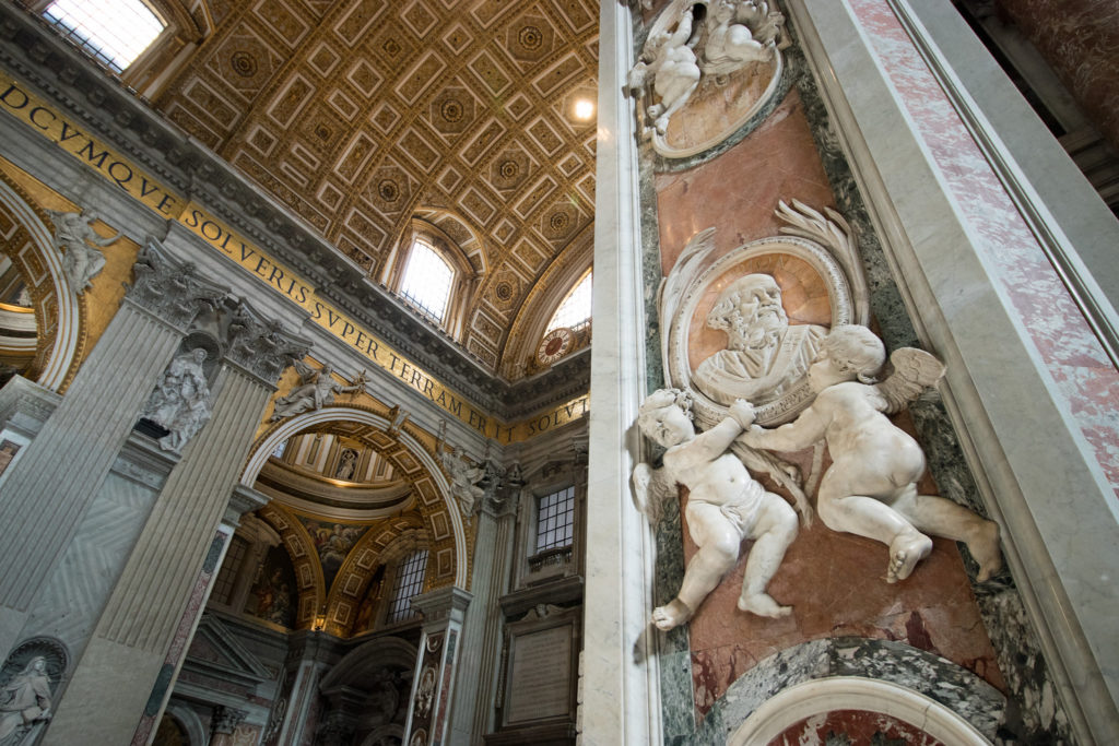 wings cherubs hold a marble relief in St. Peter's Basilica