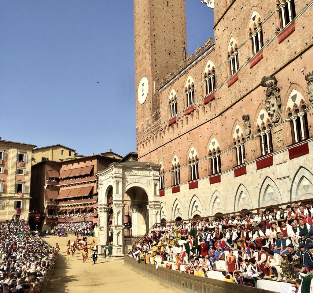 horses racing past Palazzo Pubblico during the Palio
