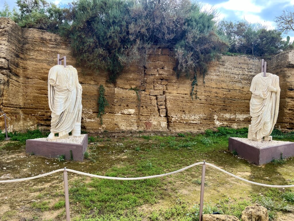 statues on temporary display along the ruins of the city walls