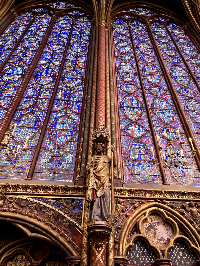 stained glass and an apostle in the upper chapel