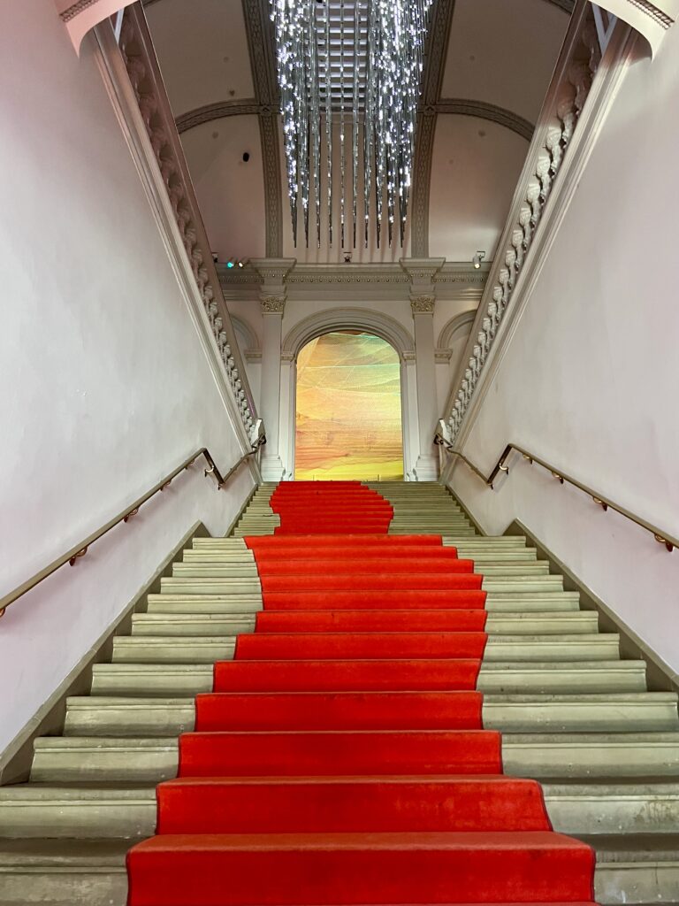 grand staircase with red carpet in the Renwick Gallery
