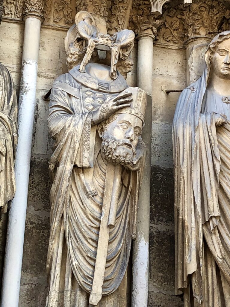 statue of the headless Saint Denis on the cathedral facade