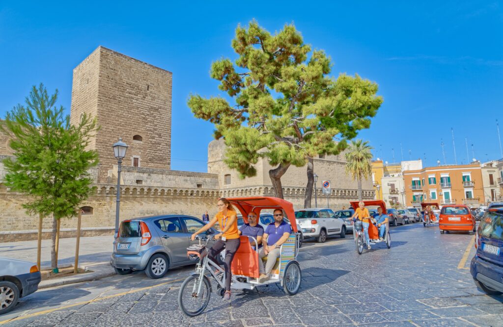 rickshaws passing by Castle Svevo