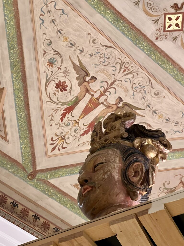 buddha bust against ceiling fresco