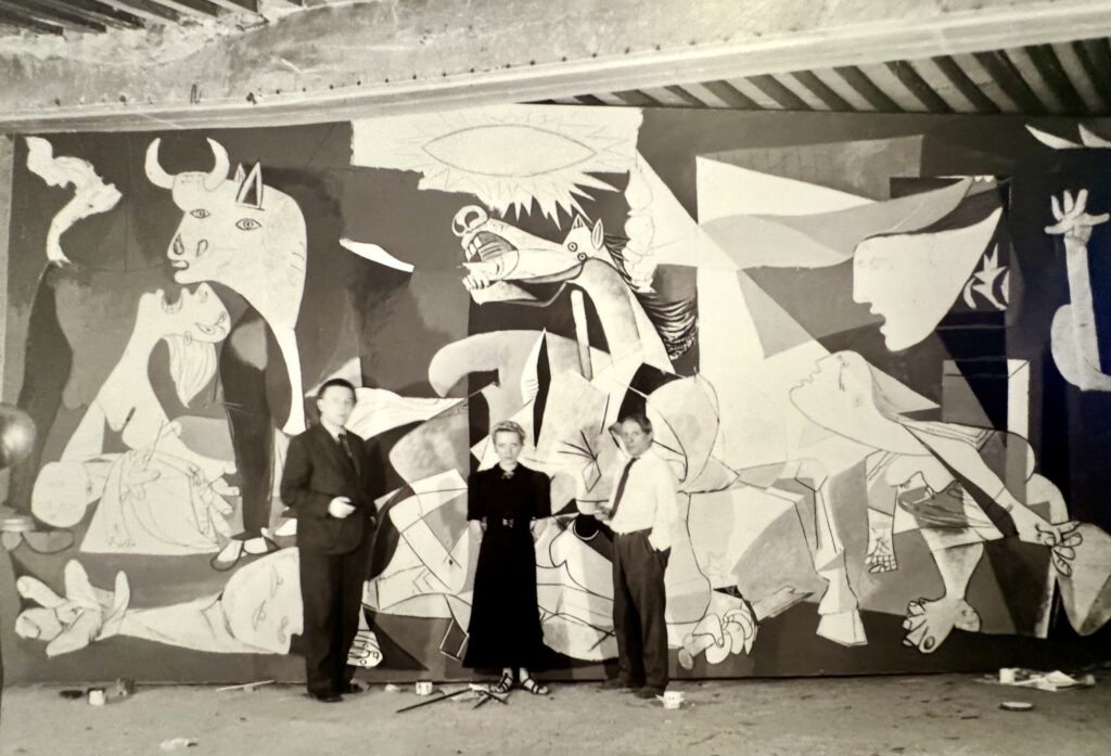 photo of Picasso and others in front of Guernica