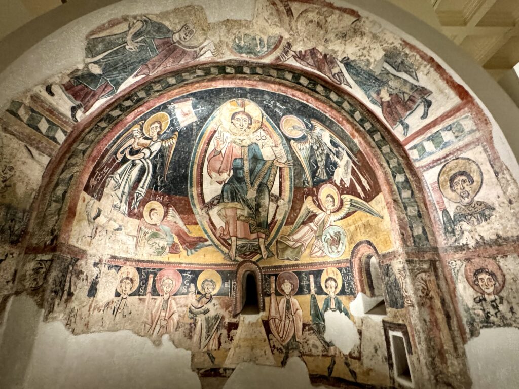Romanesque fresco hosting Christ in majesty surrounded by saints and angels