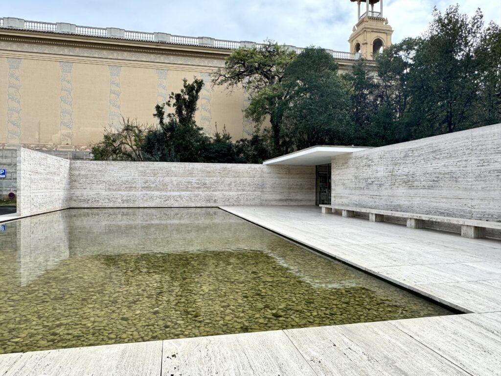 pool at front entryway of white travertine and a stones in the bottom