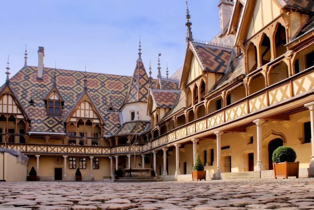 Flamboyant Gothic architecture of Hotel Dieu with its polychrome glazed roof, as seen from the courtyard.