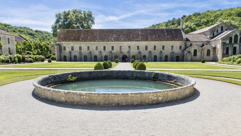 view of Fontenay Abbey with a fountain in front