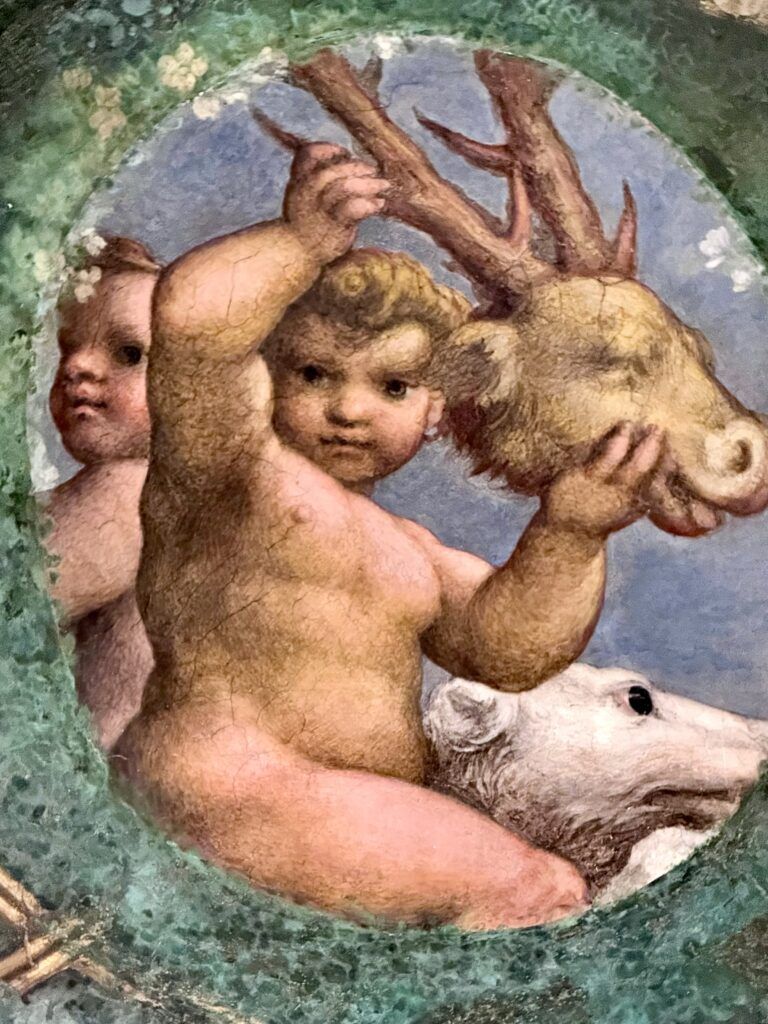 putti holding a ram's head